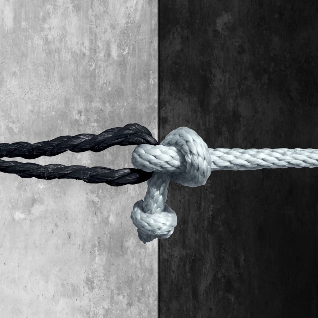 Racial unity concept as a symbol against racism in society as a white and black rope tied together as a metaphor for friendship and respect.